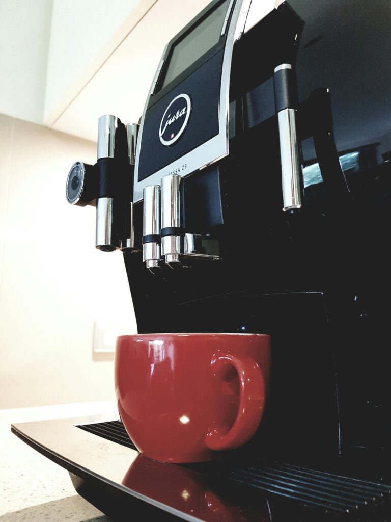 pexels-photo-362216-362216 Sleek espresso machine with red coffee cup in bright kitchen setting, ideal for modern cafes.
